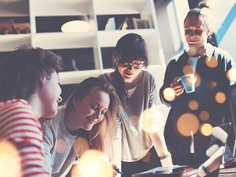 Young people working on a project while drinking coffee and chatting